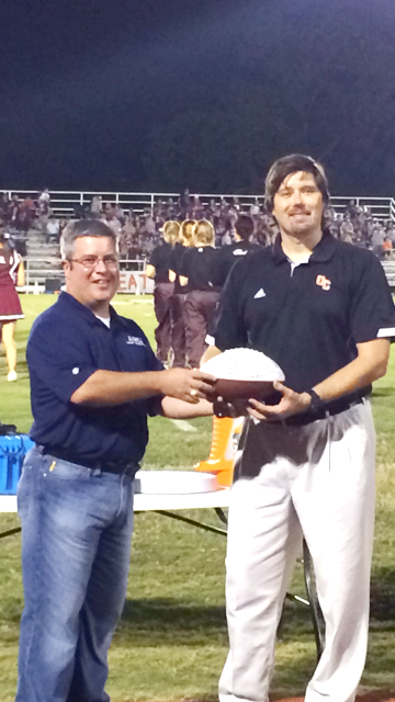 Doctor Richard Hozdic receives a signed football presented by Jason Rawls of Rawls Insurance and Financial Services for being Fan of the Week.