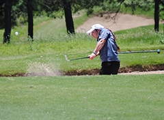 AHS senior, Haley Ware, sprays sand into the air as she safely hits the ball out of a sandtrap.