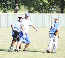 Linden-Kildare head coach John Roberts teaches young ball players the correct way to plant their feet before making a throw to a teammate.